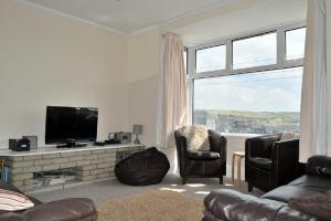 Trenwith في بيرانبورث: غرفة معيشة مع تلفزيون وأريكة وكراسي