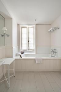 a white bathroom with a tub and a window at Villa Clarisse in Saint-Martin-de-Ré