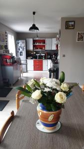 a vase of flowers on a table in a kitchen at VOLCANS D'AUVERGNE - PONTAUMUR in Pontaumur
