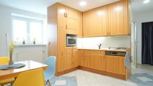 a kitchen with wooden cabinets and a table with chairs at Apartmány Monty in Karlovy Vary
