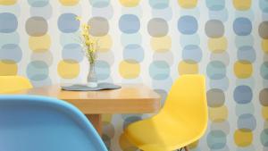 a dining room table with a vase of flowers and chairs at Apartmány Monty in Karlovy Vary