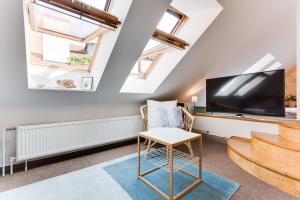 a living room with a flat screen tv and a table at Charles Bridge Loft in Prague
