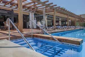 a pool at a hotel with chairs and tables at Dulce Nombre Tarifa in Tarifa