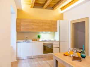 a kitchen with white cabinets and a wooden table at Casa Ristori in Cividale del Friuli
