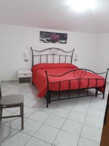 - une chambre avec un lit rouge et une chaise dans l'établissement Appartamento Ariosto, à Bosa
