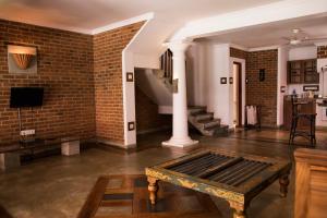 una sala de estar con una pared de ladrillo y una mesa en Villa Araliya, en Negombo
