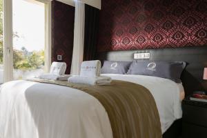 a bedroom with a large bed with towels on it at Villa Canterbury in Luxembourg