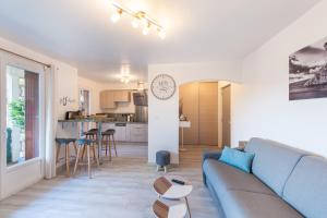 een woonkamer met een blauwe bank en een keuken bij Apartment T2 Confort - Calme - Proche plage in La Ciotat
