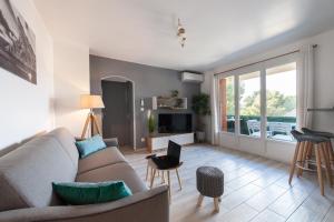 ein Wohnzimmer mit einem Sofa und einem TV in der Unterkunft Apartment T2 Confort - Calme - Proche plage in La Ciotat