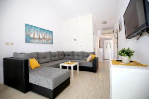 a living room with a couch and a tv at Villa Mičić in Zadar