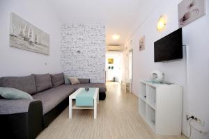 ein Wohnzimmer mit einem Sofa und einem Tisch in der Unterkunft Villa Mičić in Zadar