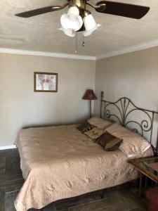 a bedroom with a bed with a ceiling fan at Capri Beach Hotel in Corpus Christi