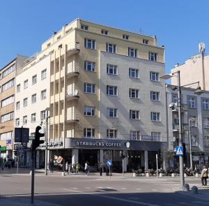 een groot gebouw in een stadsstraat met mensen die voor de deur lopen bij Apartamenty Mirada in Gdynia