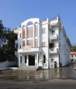 um edifício branco com uma placa na frente dele em K.C Residence em Yangon