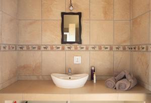 a bathroom with a sink and a mirror and towels at Sangasava Safari Lodge in Balule Game Reserve +37 photos