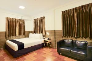 una camera con letto e sedia in pelle nera di K.C Residence a Yangon
