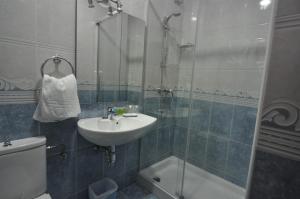 a bathroom with a sink and a toilet and a shower at Pension Alameda in San Sebastián