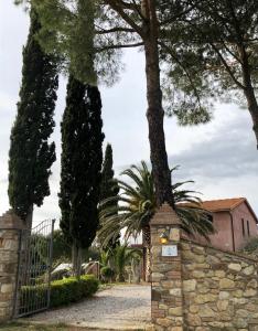 ビッボーナにあるTenuta De Fanti Agriturismoの木々と建物のある別荘への門