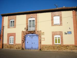 un grande edificio in mattoni con una porta blu di Hotel Rural La Rosa de los Tiempos a Carneros