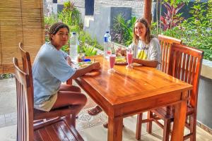 two people sitting at a wooden table at The Mountain Cottage in Nusa Penida +21 photos