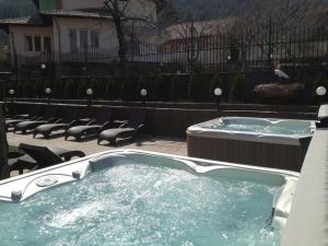a jacuzzi tub in a yard with chairs at Family Hotel Emaly Green in Sapareva Banya