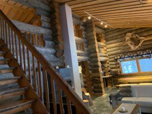 a staircase in a log cabin with a living room at Casa Levi Luxury Chalet in Levi