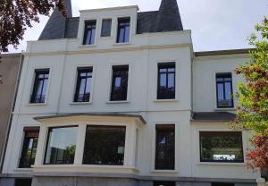a white house with black windows and a roof at La maison des dentelliers in Calais +12 photos