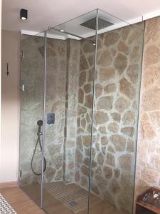 een douche in een kamer met een stenen muur bij aznalmara loft rural in Benaocaz