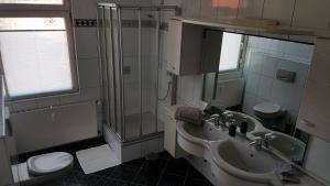 a bathroom with a sink and a toilet and a shower at Zimmervermietung Mülheim in Mülheim an der Ruhr