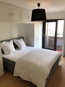 a bedroom with a large bed with white sheets and pillows at Ocean Breeze in Ostend