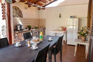 a kitchen with a table with chairs and a refrigerator at Le Ville di Porto Ada in Pizzo