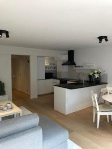 een keuken en een woonkamer met een bank en een tafel bij Ocean Breeze in Oostende