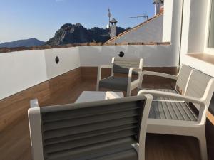 a balcony with two benches and a view of the mountains at aznalmara loft rural in Benaocaz