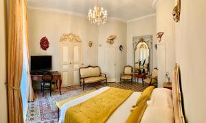 a bedroom with a bed and a desk and a television at Villa Rosa Béziers in Béziers