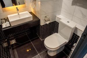 uma casa de banho com um WC branco e um lavatório. em O&G Hotel Parit Buntar em Parit Buntar