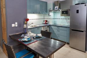 uma cozinha com uma mesa de madeira e um frigorífico em Appartements Cayenne Standing em Caiena