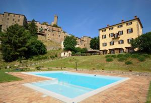 une grande piscine en face d'un bâtiment dans l'établissement Country House il Ciliegio, à Roccatederighi