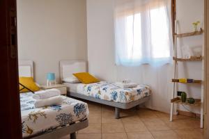 a bedroom with two beds and a window at Le Ville di Porto Ada in Pizzo +46 photos