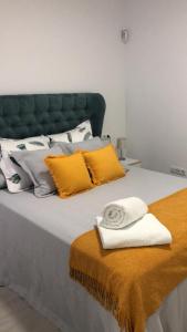 - un lit avec des oreillers jaunes et blancs dans l'établissement FUENGIROLA SWEET & BEACH, à Fuengirola