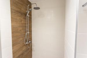 a shower in a bathroom with white tiles at Cloud 3 Apartment in Kalamata