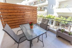 a table and chairs on a balcony with a wooden wall at Cloud 3 Apartment in Kalamata
