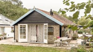 Casa pequeña de ladrillo con porche y patio en Bed & Breakfast de Appelaar, en Rijs