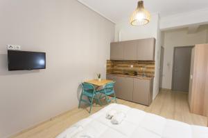 a room with a bed and a table and a kitchen at Cloud 3 Apartment in Kalamata