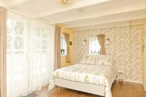 1 dormitorio con 1 cama con papel pintado con motivos florales en Bed & Breakfast de Appelaar, en Rijs