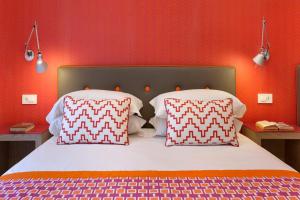 ein Bett mit zwei Kissen und einer roten Wand in der Unterkunft Casa Dominova de Luxe in Sorrent
