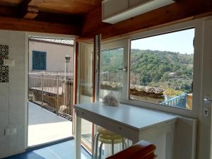 a kitchen with a counter and a large window at Casa Mancusa in Badolato