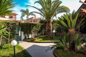 a courtyard with palm trees in a house at Le Ville di Porto Ada in Pizzo