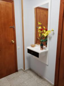 un baño con lavabo con un jarrón de flores. en Can Cristina, en Aldover