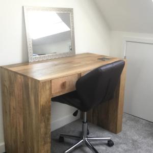 a wooden desk with a mirror and a chair at Idyllic Studio Flat in Winchester