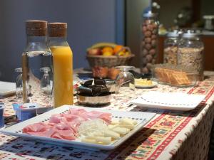 einen Tisch mit einem Teller mit Lebensmitteln und Flaschen Orangensaft in der Unterkunft b&b la mondina in Palazzolo Vercellese